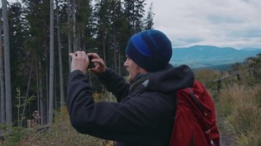 adam onun smartphone kullanarak dağlarda fotoğraf çekmek