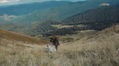 Genç çift Sibirya husky köpek ile dağlarda hiking