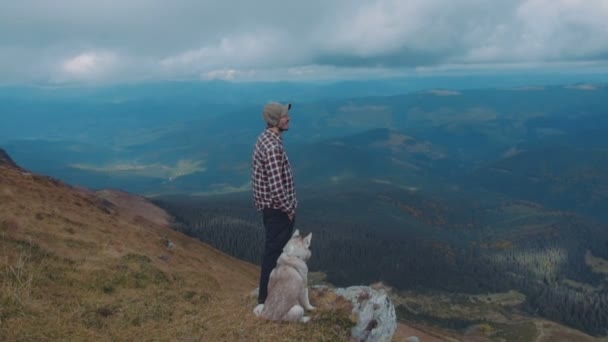 高加索男性徒步旅行在山与西伯利亚沙哑的狗 — 图库视频影像