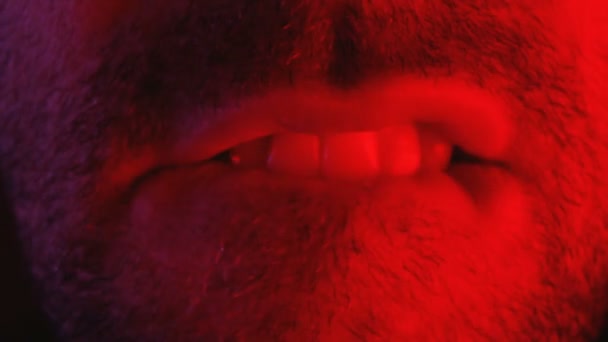 Makro närbild på mannen med förförisk ansiktsuttryck bita hans läppar — Stockvideo