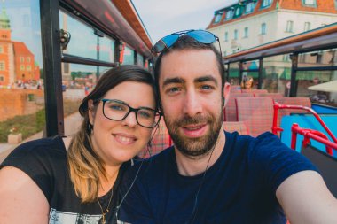 Mutlu çift smartphone ya da bir otobüs tur içinde kamera ile bir selfie alarak.