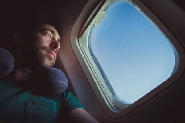 Людина Подушкою Шиї Дивиться Надворі Через Вікно Літака — стокове фото