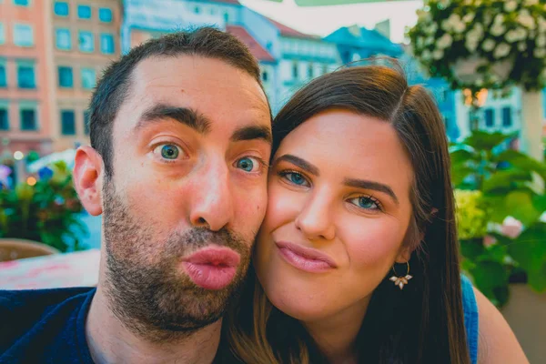 通りでスマート フォンやカメラで Selfie を取って幸せな若いカップル 彼らは愚かな 面白い顔を作る — ストック写真