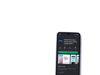 Lod, Israel - 8 Temmuz 2020: Adobe Photoshop Express Fotoğraf Editörü uygulama oyun sayfası beyaz arkaplanda izole edilmiş siyah bir cep telefonu ekranında. Üst görünüm düzlüğü kopyalama alanı ile yatıyordu.