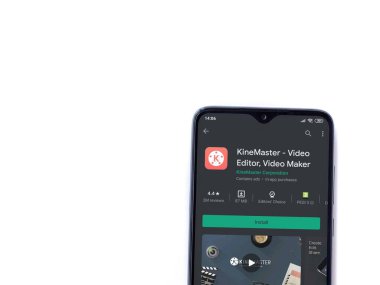 Lod, Israel - 8 Temmuz 2020: KineMaster - Video Editörü ve Film Yapıcı uygulaması oyun sayfası beyaz arkaplanda izole edilmiş siyah bir cep telefonu ekranında. Üst görünüm düzlüğü kopyalama alanı ile yatıyordu.