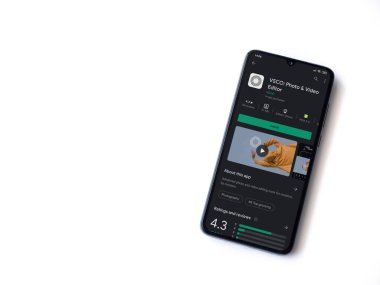 Lod, Israel - 8 Temmuz 2020: VSCO - Fotoğraf & Video Editörü uygulama oyun sayfası beyaz arkaplanda izole edilmiş siyah bir cep telefonu ekranında. Üst görünüm düzlüğü kopyalama alanı ile yatıyordu. 