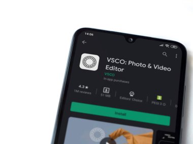 Lod, Israel - 8 Temmuz 2020: VSCO - Fotoğraf & Video Editörü uygulama oyun sayfası beyaz arkaplanda izole edilmiş siyah bir cep telefonu ekranında. Üst görünüm düzlüğü kopyalama alanı ile yatıyordu. 