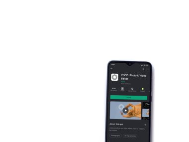 Lod, Israel - 8 Temmuz 2020: VSCO - Fotoğraf & Video Editörü uygulama oyun sayfası beyaz arkaplanda izole edilmiş siyah bir cep telefonu ekranında. Üst görünüm düzlüğü kopyalama alanı ile yatıyordu. 