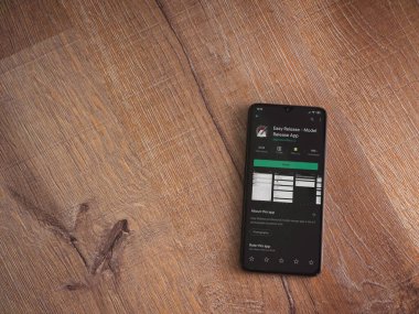 Lod, Israel - 8 Temmuz 2020: Easy Release Pro - Model Sürüm uygulaması oyun mağazası sayfası ahşap arka planda siyah bir cep telefonu görüntüsü. Üst görünüm düzlüğü kopyalama alanı ile yatıyordu. 