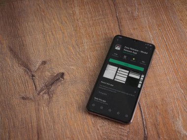 Lod, Israel - 8 Temmuz 2020: Easy Release Pro - Model Sürüm uygulaması oyun mağazası sayfası ahşap arka planda siyah bir cep telefonu görüntüsü. Üst görünüm düzlüğü kopyalama alanı ile yatıyordu. 