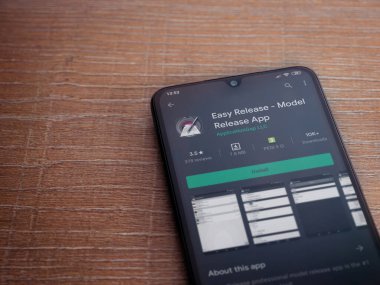 Lod, Israel - 8 Temmuz 2020: Easy Release Pro - Model Sürüm uygulaması oyun mağazası sayfası ahşap arka planda siyah bir cep telefonu görüntüsü. Üst görünüm düzlüğü kopyalama alanı ile yatıyordu. 