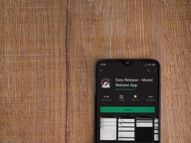 Lod, Israel - 8 Temmuz 2020: Easy Release Pro - Model Sürüm uygulaması oyun mağazası sayfası ahşap arka planda siyah bir cep telefonu görüntüsü. Üst görünüm düzlüğü kopyalama alanı ile yatıyordu. 