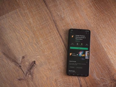 Lod, Israel - 8 Temmuz 2020: Pixaloop uygulaması oyun mağazası sayfasını ahşap arka planda siyah bir cep telefonunun ekranında aydınlat. Üst görünüm düzlüğü kopyalama alanı ile yatıyordu.