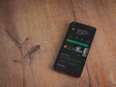 Lod, Israel - 8 Temmuz 2020: Pixaloop uygulaması oyun mağazası sayfasını ahşap arka planda siyah bir cep telefonunun ekranında aydınlat. Üst görünüm düzlüğü kopyalama alanı ile yatıyordu.