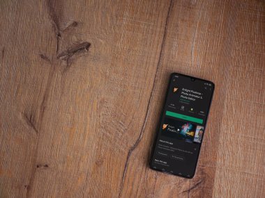 Lod, Israel - 8 Temmuz 2020: Pixaloop uygulaması oyun mağazası sayfasını ahşap arka planda siyah bir cep telefonunun ekranında aydınlat. Üst görünüm düzlüğü kopyalama alanı ile yatıyordu.