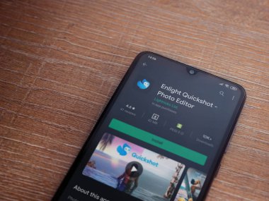 Lod, Israel - 8 Temmuz 2020: Ahşap arka planda siyah bir cep telefonu ekranında Quickshot uygulaması oyun mağazası sayfasını aydınlat. Üst görünüm düzlüğü kopyalama alanı ile yatıyordu.