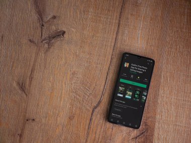 Lod, Israel - 8 Temmuz 2020: EyeEm - Ahşap arka planda siyah bir cep telefonunun ekranında resim paylaşımı ve satışı uygulaması oyun sayfası. Üst görünüm düzlüğü kopyalama alanı ile yatıyordu.