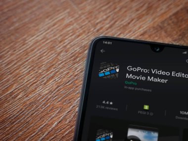 Lod, Israel - 8 Temmuz 2020: GoPro - Video Editörü ve Film Yapımcısı uygulama oyun sayfası ahşap arka planda siyah bir cep telefonunun ekranında. Üst görünüm düzlüğü kopyalama alanı ile yatıyordu.