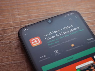 Lod, Israel - 8 Temmuz 2020: VivaVideo - Video Editörü ve Film Yapımcısı uygulama oyun sayfası ahşap arka planda siyah bir cep telefonunun ekranında. Üst görünüm düzlüğü kopyalama alanı ile yatıyordu.