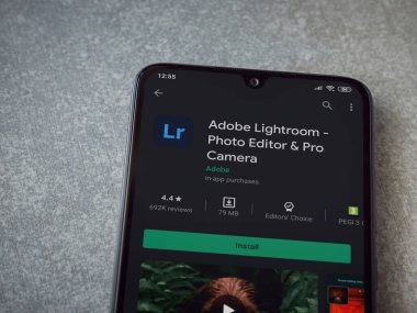 Lod, Israel - 8 Temmuz 2020: Adobe Lightroom - Fotoğraf Editörü ve Pro Camera uygulama oyun sayfası seramik taş zemin üzerinde siyah bir cep telefonu sergilenmektedir. Üst görünüm düzlüğü kopyalama alanı ile yatıyordu.