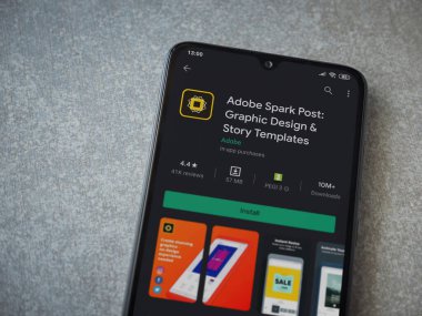 Lod, Israel - 8 Temmuz 2020: Adobe Spark Post - Grafik Tasarım ve Hikaye Şablonları uygulama oyun sayfası seramik taş arka planda siyah bir cep telefonu görüntüsü. Üst görünüm düzlüğü düz bir şekilde fotokopi alanı ile yatıyordu