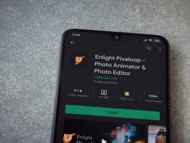 Lod, Israel - 8 Temmuz 2020: Pixaloop uygulaması oyun mağazası sayfasını seramik taş zemin üzerinde siyah bir cep telefonu ekranında aydınlat. Üst görünüm düzlüğü kopyalama alanı ile yatıyordu.