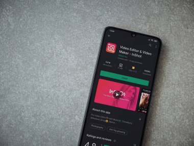 Lod, Israel - 8 Temmuz 2020: Inshot - Video Editörü ve Film Yapımcısı uygulama oyun sayfası seramik taş zemin üzerinde siyah bir cep telefonunun ekranında. Üst görünüm düzlüğü kopyalama alanı ile yatıyordu.