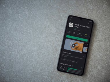 Lod, Israel - 8 Temmuz 2020: VSCO - Fotoğraf ve Video Editörü uygulama oyun sayfası seramik taş zemin üzerinde siyah bir cep telefonu ekranında. Üst görünüm düzlüğü kopyalama alanı ile yatıyordu. 
