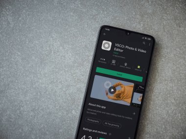 Lod, Israel - 8 Temmuz 2020: VSCO - Fotoğraf ve Video Editörü uygulama oyun sayfası seramik taş zemin üzerinde siyah bir cep telefonu ekranında. Üst görünüm düzlüğü kopyalama alanı ile yatıyordu. 