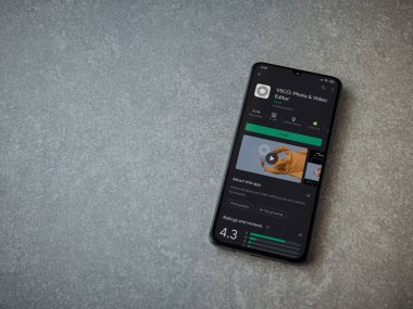 Lod, Israel - 8 Temmuz 2020: VSCO - Fotoğraf ve Video Editörü uygulama oyun sayfası seramik taş zemin üzerinde siyah bir cep telefonu ekranında. Üst görünüm düzlüğü kopyalama alanı ile yatıyordu. 