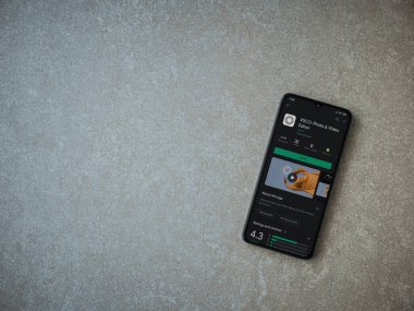 Lod, Israel - 8 Temmuz 2020: VSCO - Fotoğraf ve Video Editörü uygulama oyun sayfası seramik taş zemin üzerinde siyah bir cep telefonu ekranında. Üst görünüm düzlüğü kopyalama alanı ile yatıyordu. 