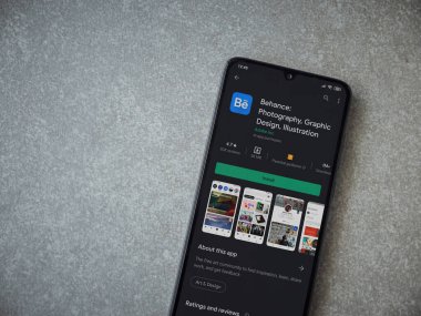 Lod, Israel - 8 Temmuz 2020: Adobe Behance uygulaması oyun mağazası sayfası seramik taş zemin üzerinde siyah bir cep telefonu görüntüsü. Üst görünüm düzlüğü kopyalama alanı ile yatıyordu. 