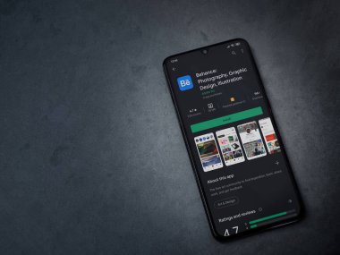 Lod, Israel - 8 Temmuz 2020: Adobe Behance uygulaması oyun mağazası sayfası koyu mermer taştan bir arka planda siyah bir cep telefonunun ekranında. Üst görünüm düzlüğü kopyalama alanı ile yatıyordu. 