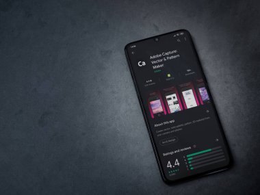 Lod, Israel - 8 Temmuz 2020: Adobe Capture - Vector and Destern Maker uygulama oyun mağazası sayfası koyu mermer taşlı arka planda siyah bir cep telefonu görüntüsü. Üst görünüm düzlüğü kopyalama alanı ile yatıyordu.