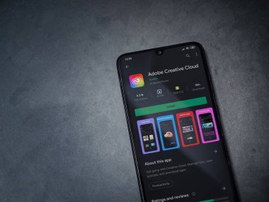 Lod, Israel - 8 Temmuz 2020: Yaratıcı Bulut uygulaması oyun mağazası sayfası koyu mermer taştan bir arka planda siyah bir cep telefonu sergilenmektedir. Üst görünüm düzlüğü kopyalama alanı ile yatıyordu.