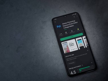 Lod, Israel - 8 Temmuz 2020: Adobe Photoshop Express Fotoğraf Editörü uygulama oyun sayfası koyu mermer taştan bir arka planda siyah bir cep telefonunun ekranında. Üst görünüm düzlüğü kopyalama alanı ile yatıyordu.
