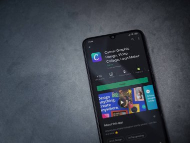 Lod, Israel - 8 Temmuz 2020: Canva - Grafik Tasarım uygulaması oyun mağazası sayfası koyu mermer taştan bir arka planda siyah bir cep telefonu sergilenmektedir. Üst görünüm düzlüğü kopyalama alanı ile yatıyordu. 