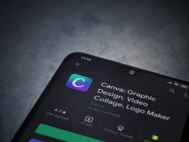 Lod, Israel - 8 Temmuz 2020: Canva - Grafik Tasarım uygulaması oyun mağazası sayfası koyu mermer taştan bir arka planda siyah bir cep telefonu sergilenmektedir. Üst görünüm düzlüğü kopyalama alanı ile yatıyordu. 