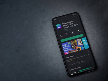 Lod, Israel - 8 Temmuz 2020: Canva - Grafik Tasarım uygulaması oyun mağazası sayfası koyu mermer taştan bir arka planda siyah bir cep telefonu sergilenmektedir. Üst görünüm düzlüğü kopyalama alanı ile yatıyordu. 