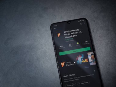 Lod, Israel - 8 Temmuz 2020: Pixaloop uygulaması oyun mağazası sayfasını koyu mermer taşlı arka planda siyah bir cep telefonunun ekranında aydınlat. Üst görünüm düzlüğü kopyalama alanı ile yatıyordu.