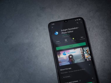 Lod, Israel - 8 Temmuz 2020: Quickshot uygulaması oyun mağazası sayfasını koyu mermer taştan bir arka planda siyah bir cep telefonuyla aydınlat. Üst görünüm düzlüğü kopyalama alanı ile yatıyordu.