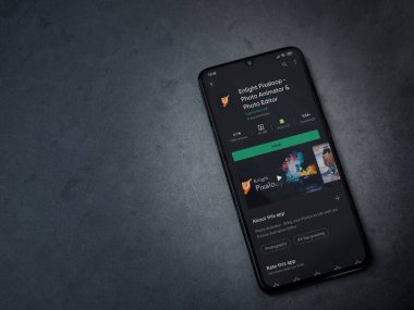 Lod, Israel - 8 Temmuz 2020: Pixaloop uygulaması oyun mağazası sayfasını koyu mermer taşlı arka planda siyah bir cep telefonunun ekranında aydınlat. Üst görünüm düzlüğü kopyalama alanı ile yatıyordu.