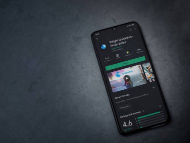 Lod, Israel - 8 Temmuz 2020: Quickshot uygulaması oyun mağazası sayfasını koyu mermer taştan bir arka planda siyah bir cep telefonuyla aydınlat. Üst görünüm düzlüğü kopyalama alanı ile yatıyordu.