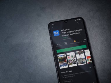 Lod, Israel - 8 Temmuz 2020: Adobe Behance uygulaması oyun mağazası sayfası koyu mermer taştan bir arka planda siyah bir cep telefonunun ekranında. Üst görünüm düzlüğü kopyalama alanı ile yatıyordu. 