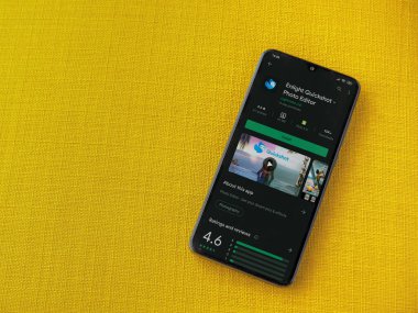 Lod, Israel - 8 Temmuz 2020: Sarı kumaş arka planda siyah bir cep telefonunun ekranında Quickshot uygulaması oyun mağazası sayfasını aydınlat. Üst görünüm düzlüğü kopyalama alanı ile yatıyordu.