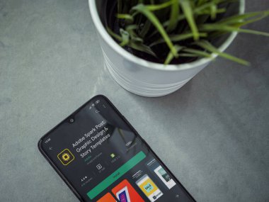Lod, Israel - 8 Temmuz 2020: Mermer arka planda Adobe Spark Post uygulama mağazası sayfası olan siyah cep telefonlu modern minimalist ofis çalışma alanı. Üst görünüm yatağını kapat.