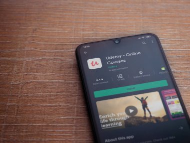 Lod, Israel - 8 Temmuz 2020: Ahşap arka planda siyah bir cep telefonunun ekranında Udemy uygulaması oyun mağazası sayfası. Üst görünüm düzlüğü kopyalama alanı ile yatıyordu.