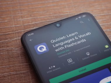 Lod, Israel - 8 Temmuz 2020: Quizlet - Dil öğrenme uygulaması oyun mağazası sayfası ahşap arka planda siyah bir cep telefonu görüntüsü. Üst görünüm düzlüğü kopyalama alanı ile yatıyordu.