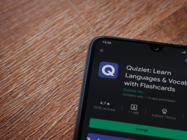 Lod, Israel - 8 Temmuz 2020: Quizlet - Dil öğrenme uygulaması oyun mağazası sayfası ahşap arka planda siyah bir cep telefonu görüntüsü. Üst görünüm düzlüğü kopyalama alanı ile yatıyordu.