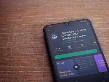 Lod, Israel - 8 Temmuz 2020: Mimo - Ahşap arka planda siyah bir cep telefonunun ekranında kodlama uygulaması oyun mağazası sayfası öğreniyor. Üst görünüm düzlüğü kopyalama alanı ile yatıyordu.